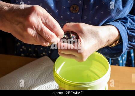 Sorbische Ostereier, Wachsbatik, achter Schritt: Das verzierte Hühnerei wird mit einer spitzen Nadel durchbohrt, damit es herausgeblasen werden kann. Stockfoto