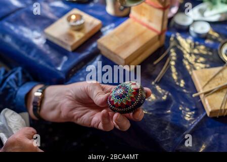 Sorbische Ostereier, Wachsbatik, zehnte Stufe: Das Wachs auf dem verzierten Hühnerei wird erhitzt und anschließend mit einem Lappen abgewischt. Stockfoto