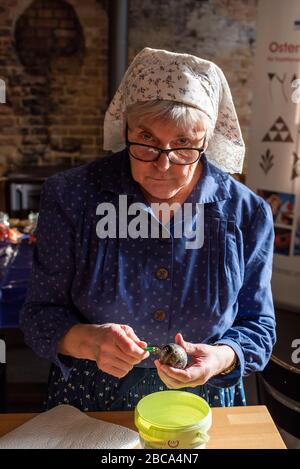 Sorbische Ostereier, Wachsbatik, achter Schritt: Das verzierte Hühnerei wird mit einer spitzen Nadel durchbohrt, damit es herausgeblasen werden kann. Stockfoto