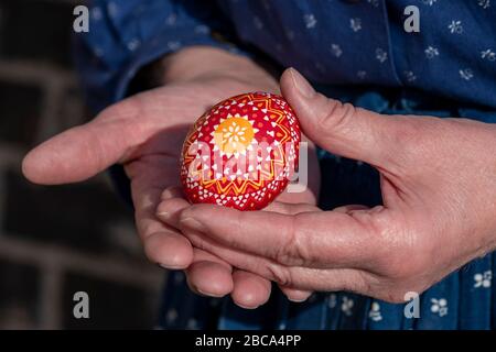 Eine Frau hält ein sorbisches Osterei in der Hand. Sie war mit der Wachsbatik verziert. Stockfoto