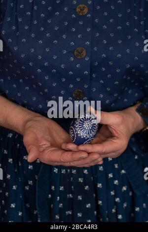 Eine Frau hält ein sorbisches Osterei in der Hand. Sie war mit der Wachsbatik verziert. Stockfoto