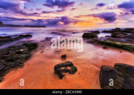 Sandstrände rund um Turimetta entlang der Nordstrände von Sydney bei Sonnenaufgang. Stockfoto