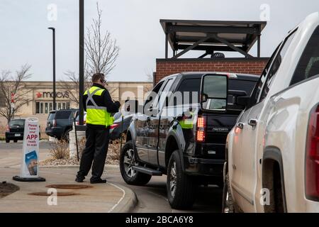 Maplewood, Minnesota. Ein Mitarbeiter in einem Fast-Food-Restaurant, der Kreditkarten außerhalb von Kunden abnimmt, um seine Bestellungen in sicherer Entfernung zu bezahlen Stockfoto
