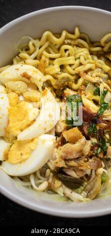 soto ayam ist traditionelles Essen aus indonesien, serviert mit Huhn, Nudeln, Ei, Sambal und gebratenen Zwiebeln Stockfoto