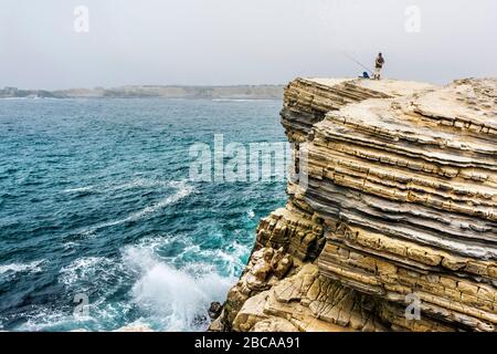 Europa, Portugal, Region Centro, Peniche, einsame Angler auf einem Felsvorsprung am Meer Stockfoto