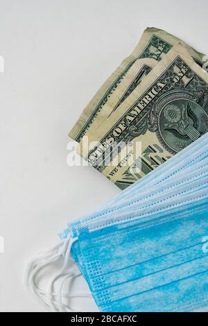 Antivirale chirurgische Masken und Geld. Hohe Gewinne aus der steigenden Nachfrage nach Schutz vor Virusinfektionen. Stockfoto