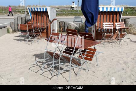 Heiligendamm, Deutschland. April 2020. Die Stühle und Tische bei einem Snack im Ostseebad sind leer, die liegen sind verschlossen. Wegen der starken Einschränkungen im öffentlichen Leben wird der traditionelle Saisonstart an der Ostsee zu Ostern in diesem Jahr gestrichen. Credit: Bernd Wüstneck / dpa-Zentralbild / dpa / Alamy Live News Stockfoto