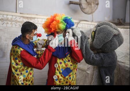 Gaza, Palästina. April 2020. Palästinensische Jugendliche, die als Clowns verkleidet sind und Schutzhandschuhe tragen, sind eine Straßenvorstellung, um Kinder zu unterhalten, die aufgrund des Corona-Virus-Ausbruchs in Khan Yunis, dem südlichen Gazastreifen, zu Hause gefangen sind. Credit: SOPA Images Limited/Alamy Live News Stockfoto