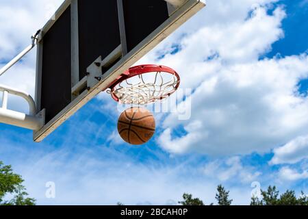 Basketballbackboard mit einem Ring auf der Straße und blauem Himmel Stockfoto