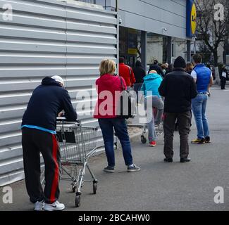 Bukarest, Rumänien - 29. März 2020: Die Menschen stehen in einem Lidl-Supermarkt nach der Regel der sozialen Distanzierung während des Ausnahmezustands wegen c Stockfoto