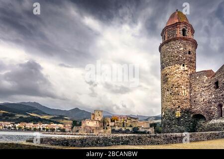 Bay de la Baleta in Collioure im Herbst. Die Kirche Notre Dames des Anges wurde Ende des 17. Das Château Royal de Collioure ist es Stockfoto