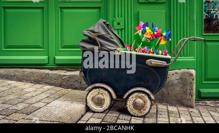 Alter Kinderwagen mit bunten Windkraftanlagen im Viertel Croix Rousse in Lyon. UNESCO-Weltkulturerbe seit 1998. Ehemalige Hochburg der Industrie Stockfoto