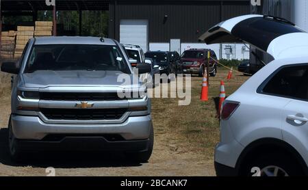 Groveland, Vereinigte Staaten. April 2020. 3. April 2020 - Groveland, Florida, Vereinigte Staaten - EINE Reihe von Autos wird wieder aufgebaut, während die Fahrer warten, um Lebensmittel von der Second Harvest Food Bank of Central Florida bei einer Drive-Through-Veranstaltung für bedürftige Familien am 3. April abzuholen. 2020 im Faith Neighborhood Center in Groveland, Florida, in der Nähe von Orlando. Die Coronavirus Pandemie hat Tausende von lokalen Servicemitarbeitern und Angestellten des Freizeitparks außer Arbeit gesetzt und belastet die Lebensmittelbanken in der Region. Credit: Paul Hennessy/Alamy Live News Stockfoto