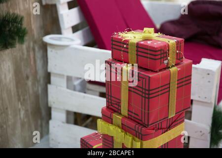 Geschenkschachteln am weihnachtsbaum. Frohes neues Jahr. Feiern Sie Weihnachten zu Hause. Winterurlaubseinkäufe. Einkaufsverkauf. Geschenklieferung. Rot, Rosa, Silber Stockfoto