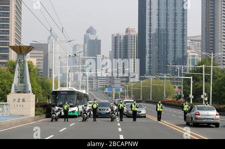 Wuhan, Chinas Provinz Hubei. April 2020. Die Polizei trauert, während der Verkehr während einer stillen Würdigung der Märtyrer stoppt, die im Kampf gegen den neuartigen Ausbruch der Coronavirus Krankheit (COVID-19) und der Landsleute, die an der Krankheit in Wuhan, der zentralen chinesischen Provinz Hubei, am 4. April 2020 gestorben sind. Credit: Shen Bohan/Xinhua/Alamy Live News Stockfoto