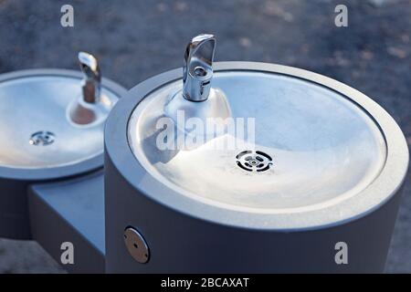 Umea, Norrland Schweden - 25. März 2020: Wasserbrunnen aus Metall und Keramik im zentralen Park Stockfoto