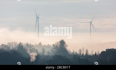 Silhouette von zwei Windkraftanlagen in der Dämmerung. In der Nähe des Starnberger Sees (Starnberger See). Energieerzeugung für bayerische Haushalte. Panoramaformat. Stockfoto