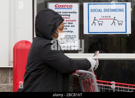 Toronto, Kanada. April 2020. Eine Frau, die eine Gesichtsmaskenlinie trägt, um ein Costco-Lagerhaus in Toronto, Kanada, am 3. April 2020 zu betreten. Credit: Zou Zheng/Xinhua/Alamy Live News Stockfoto