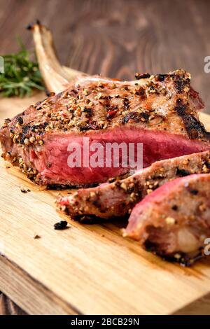 Nahaufnahme von mittelseltenem Cowboysteak auf Holzschneidebrett Stockfoto