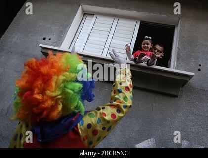 Khan Yunis, Palästina. April 2020. Ein Clown, der eine Gesichtsmaske trug, hielt eine Straßenparade zur Unterhaltung von Kindern palästinensischer wegen der Pandemie des neuen Corona-Virus (COVID-19) in Khan Yunis, südlichem Gazastreifen, Palästina, am 3. April 2020. (Foto von Yousef Masoud/INA Photo Agency/Sipa USA) Credit: SIPA USA/Alamy Live News Stockfoto