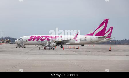 Schwoppen Sie Boeing 737-8, eine Billigfluggesellschaft im Besitz von WestJet, die in Hamilton Intl geparkt war. Flughafen an einem bewölkten Tag. Stockfoto