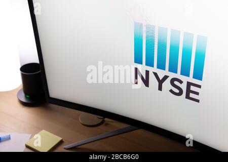 New York Stock Exchange (NYSE)-Logo wird auf einem Computermonitor auf einem Schreibtisch angezeigt. Stockfoto