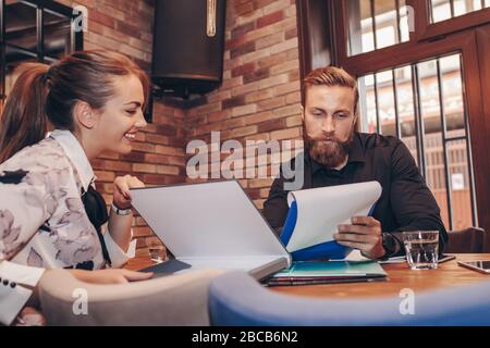 Junge Geschäftsleute zusammen Arbeiten auf Papier arbeiten und sprechen über Berichte und Finanz im Cafe. Stockfoto