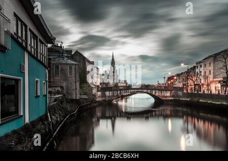 Cork City, Cork, Irland. April 2020. Blick auf den Fluss Lee am frühen Morgen mit der Parliament Bridge und der Holy Trinity Church im Hintergrund. Die Brücke ist einer der Hauptzugänge in die Stadt und ist zu diesem Zeitpunkt normalerweise mit Autos besetzt, aber aufgrund der Einschränkungen von Covid-19 und der Regierung gibt es nur wenig Verkehrsbewegungen, die in Cork City, Irland, eindringen. - Credit; David Creedon / Alamy Live News Stockfoto