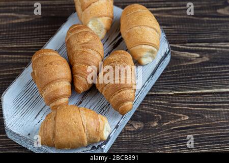 Croissants und Kaffee zum Frühstück mit frischen Himbeerblecken auf hellem Hintergrund. Mit Minze dekoriert. Kopierbereich. Stockfoto