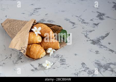 Croissants und Kaffee zum Frühstück mit frischen Himbeerblecken auf hellem Hintergrund. Mit Minze dekoriert. Kopierbereich. Stockfoto