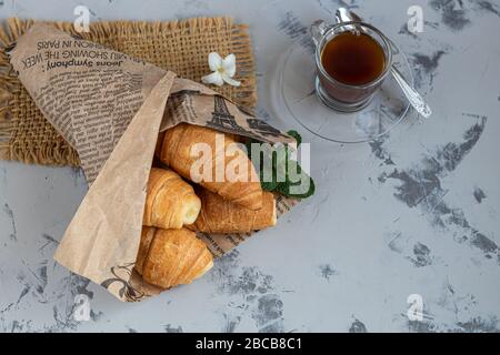 Croissants und Kaffee zum Frühstück mit frischen Himbeerblecken auf hellem Hintergrund. Mit Minze dekoriert. Kopierbereich. Stockfoto