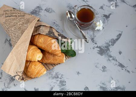 Croissants und Kaffee zum Frühstück mit frischen Himbeerblecken auf hellem Hintergrund. Mit Minze dekoriert. Kopierbereich. Stockfoto