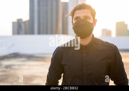 Junge persische Unternehmer denken, während sie Maske tragen, um vor dem Ausbruch des Corona-Virus und der Verschmutzung zu schützen Stockfoto