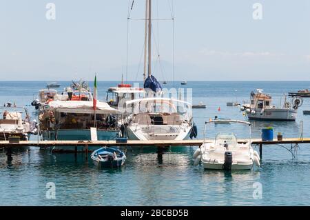 Kleine Freizeitboote, die an einem Anlegesteg im Jachthafen Amalfi vorbeifahren. Italien Stockfoto