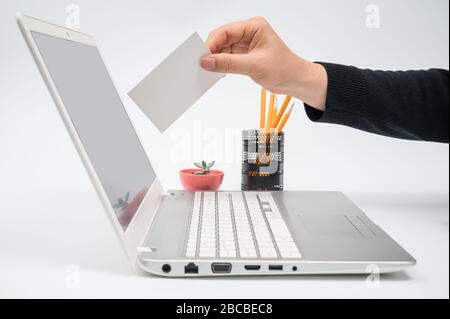 Online-Wahlkonzept mit einem Mann mit einer Wahlurne in der Hand, der eine Stimme zum Computermonitor legt. Stockfoto