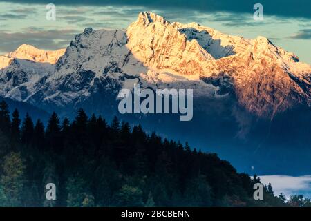 Frühmorgendliches Licht, golden leuchtend auf einer Bergflanke in den bayerischen Alpen bei Berchtesgaden Stockfoto