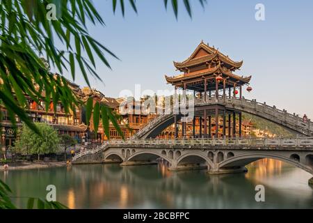 Feng Huang, China - August 2019: Lange Zeit Aufnahme der malerischen Steinbrücke über den Tuojiang-Fluss (Tuo Jiang River) und traditionellen chinesischen Archit Stockfoto