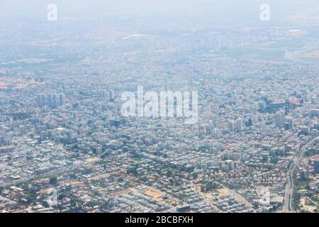 Blick auf die Stadt aus der Höhe vom Flugzeugfenster beim Start Stockfoto
