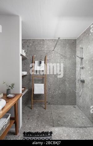 Graue Terrazzo-Dusche mit Holzdetails. Stockfoto