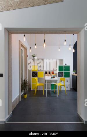 Bunte Coworking Büroecke an der Küche mit Industrielampen. Stockfoto