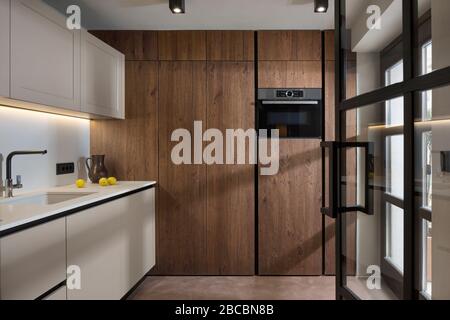 Kleine, maßgeschneiderte Küche aus Holz in netural-Farben. Stockfoto