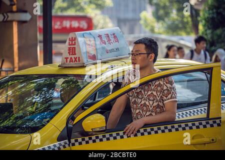 Chongqing, China - August 2019: Chinesischer Taxifahrer wartet auf einen Kundengast in der Stadt Chongqing Stockfoto
