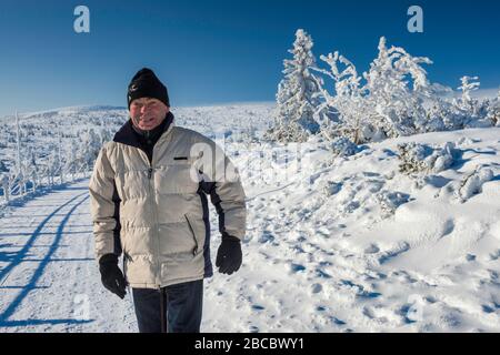 Mann in seinen sechziger Jahren Wandern im Winter, an der Holzlinie, im Karkonosze Gebirge, im Karkonosze Nationalpark, Niedermösien, Polen Stockfoto