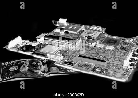 Die alte Mikroschaltung des Laptops ruht auf einer Banknote in negativer Farbe auf schwarzem Hintergrund Stockfoto