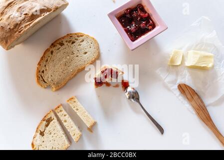 Brot, Marmelade und Butter auf Marmorgrund Stockfoto