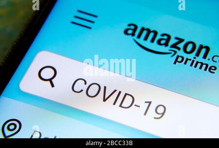 Stone/Großbritannien - 4. April 2020: Amazon Prime App Suche mit COVID-19 Wort, das auf dem Smartphone eingegeben wurde. Foto mit selektivem Fokus. Kon Stockfoto