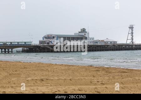 Bournemouth, Dorset UK. April 2020. Wetter in Großbritannien: Nebeliger Morgen in Bournemouth, da die Besucher rieten, zu Hause zu bleiben und sich an die Einschränkungen von Coronavirus für soziale Distanzierungen zu halten, wobei Parkplätze geschlossen sind, um Besucher abzuschrecken, die aus der Ferne fahren. Die Strände sind hauptsächlich leer, abgesehen von denen, die das Meer besuchen, um ihre erlaubten Übungen zu machen. Die Botschaft ist deutlich sichtbar durch den Nebel am Bournemouth Pier, der geschlossen ist - zu Hause zu bleiben. Credit: Carolyn Jenkins/Alamy Live News Stockfoto