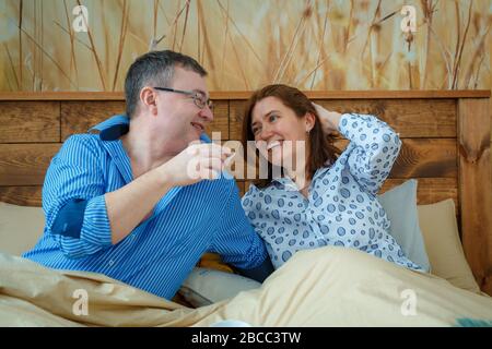 Der Ehemann brachte seiner Frau Morgenkaffee ins Bett. Bleiben Sie zu Hause und sparen Sie sich. Stockfoto