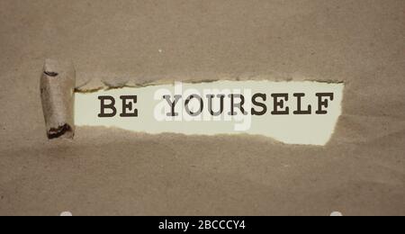 Seien Sie selbst ein Satz, der unter zerrissenem Papier geschrieben wurde. Konzept für die Markenumbildung Stockfoto