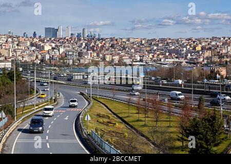 Istanbul, Türkei - 12. Februar 2020: Autos fahren von der Halich Brücke über das Goldene Horn mit dem Beyoglu Stadtteil im Hintergrund. Stockfoto